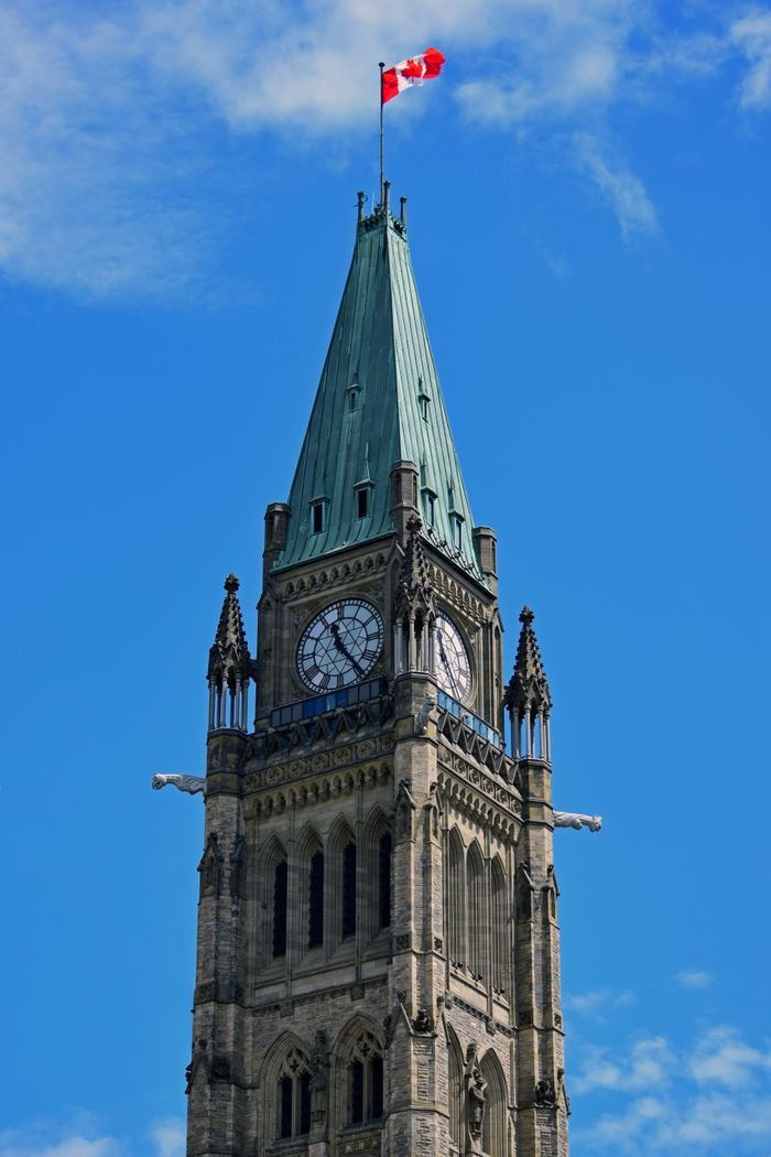 Celebrating Canada’s Diversity Through Cultural Events Low-angle view of the iconic Peace Tower against a clear blue sky in Ottawa, Canada.