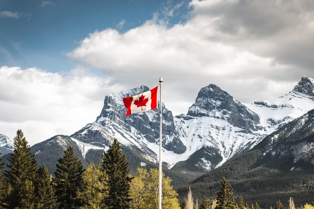 Inspiring Young Canadians Through Heritage Education Canada Canmore, Alberta. Canadian Flag with Three Sisters in the Background.